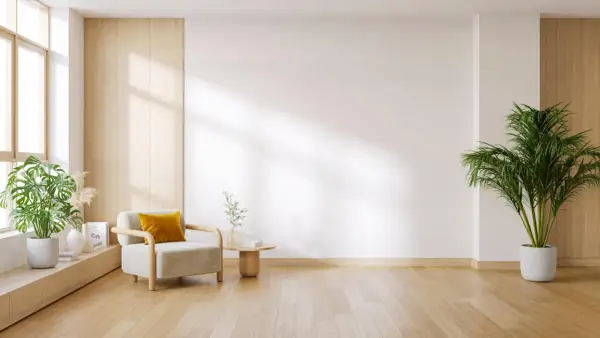Elegante salón con instalación de tarimas de madera clara, sillón acogedor y plantas verdes.