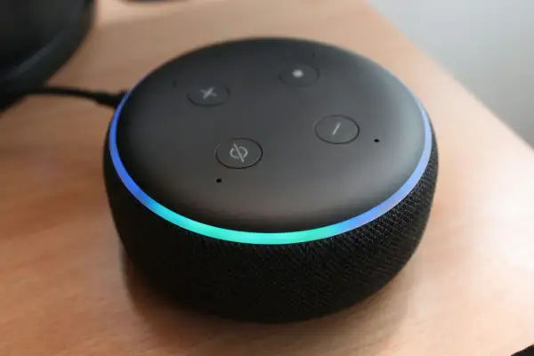 Altavoz inteligente con luz azul y verde, listo para encender Alexa y responder tus preguntas.