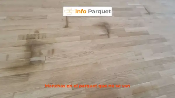 Manchas oscuras y persistentes en el parquet de madera clara, un problema común que requiere solución.
