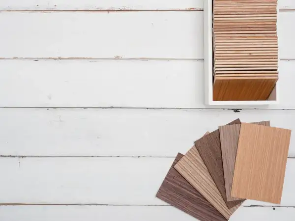 Muestras de parquet laminado de distintos tonos y grosores, dispuestas en abanico y en un expositor.