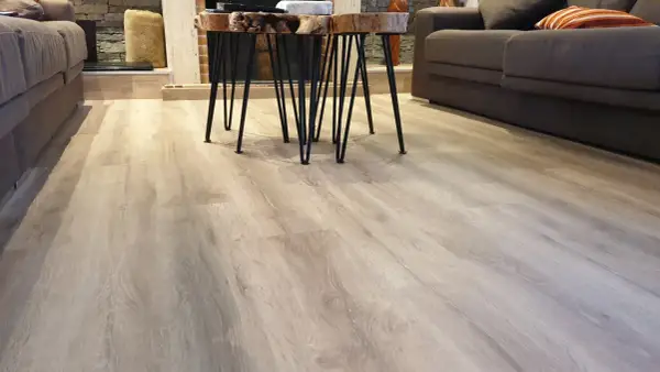 Suelo de tarima flotante de madera clara, con un diseño moderno y natural. Las medidas de la tarima flotante son perfectas para este salón.