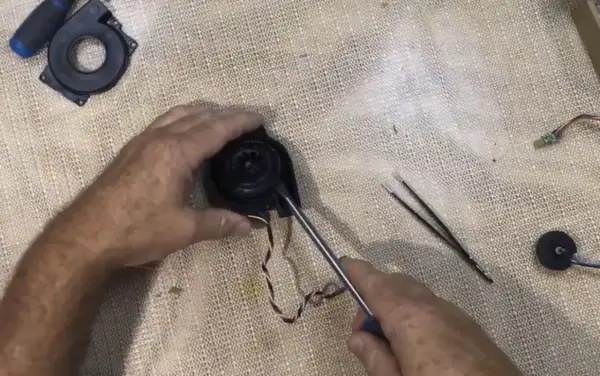 Reparando el ventilador de un Roomba con error 26. Se usa un destornillador para desmontar la pieza.